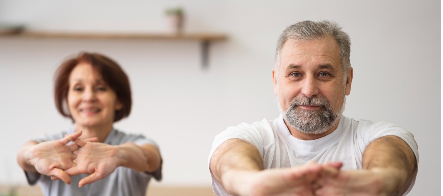 Starsza kobieta i starszy mężczyzna ćwiczą, żeby przeciwdziałać osteoporozie.